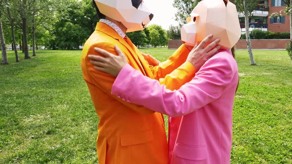 Business couple in park removing animal masks to kiss