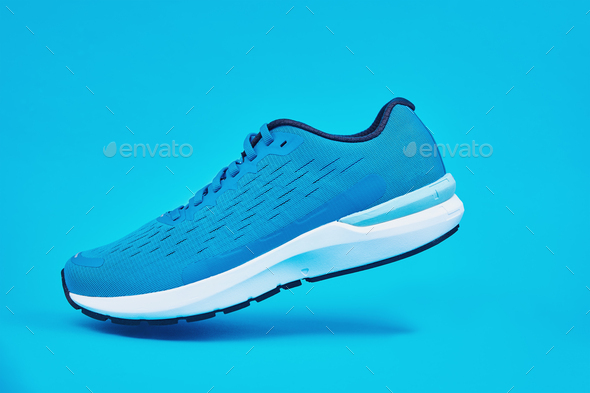 Blue running sneaker on blue background, close up