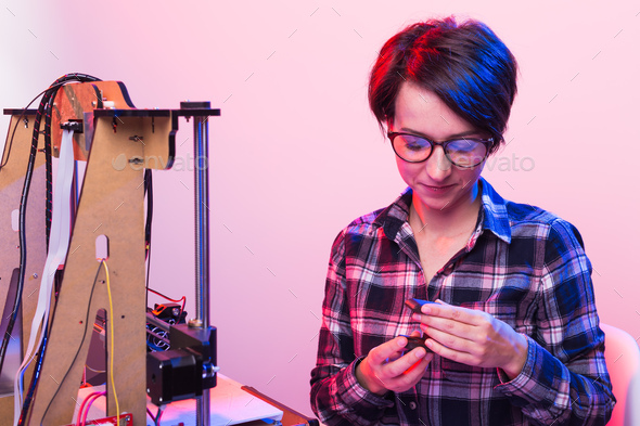 Woman student makes the item on the 3D printer
