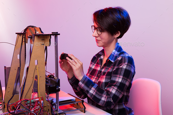 Woman student makes the item on the 3D printer