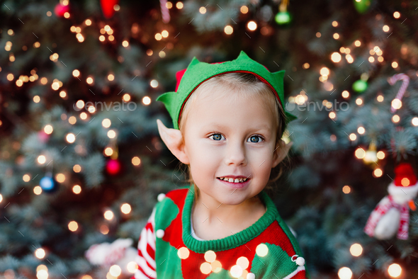 Christmas in July. Children elf ears. Portrait of little Girl decorating christmas tree