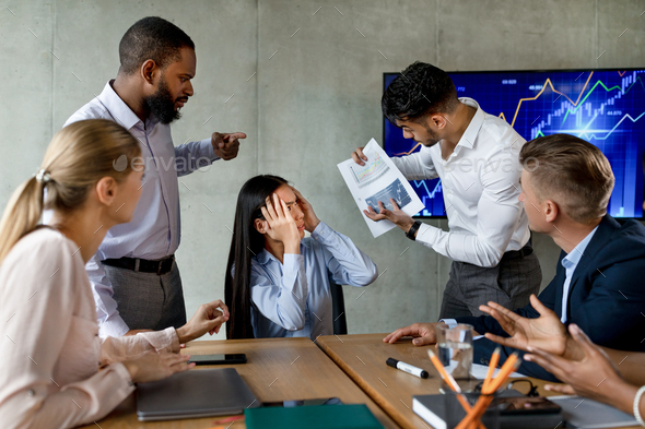 Multiethnic Team Having Conflicts At Work, Shouting At Unhappy Asian Female Employee