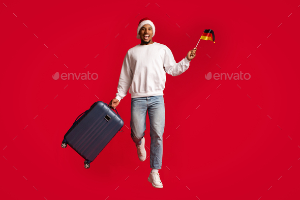 Happy black tourist with luggage tavelling to Germany on Christmas