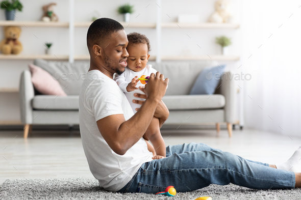 Father's Care. Young Black Man Spending Time With Infant Son At Home 