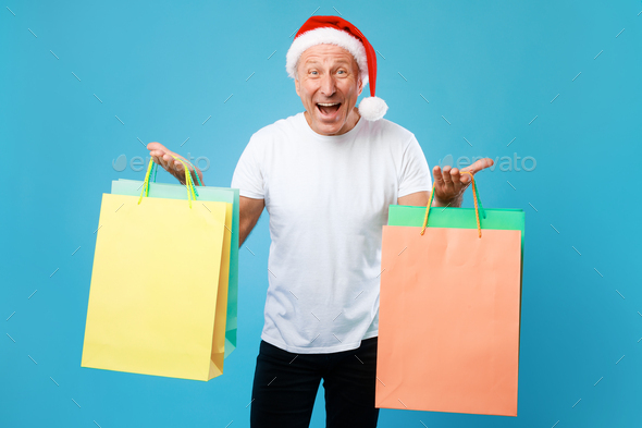 Excited man holding shopping bags at studio. Xmas Sales