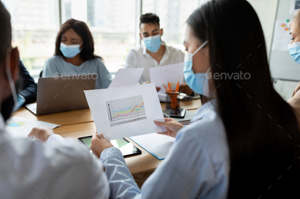 Business Team Wearing Medical Face Masks During Corporate Meeting In Office