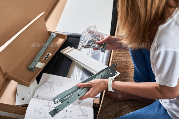 Woman reading manual instruction to assemble furniture