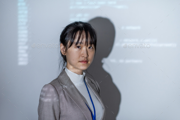 Young Asian businesswoman in formalwear standing by interactive whiteboard