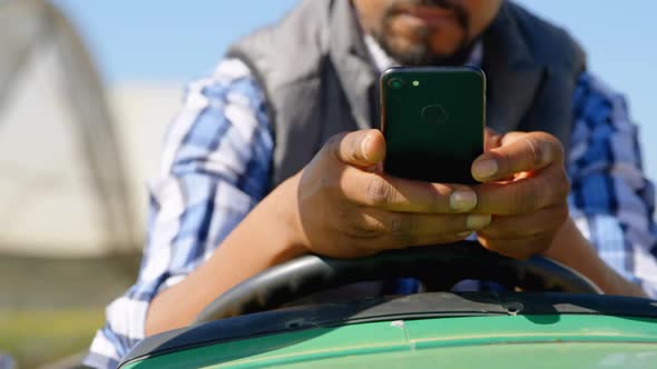 Man using mobile phone in blueberry farm 4k alt