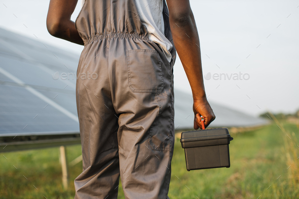 Close up of technician with tools standing on solar farm
