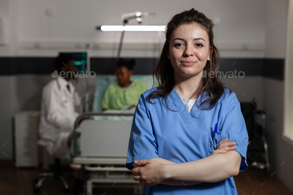 Portrait of specialist physician assistant standing in hospital ward during medical consultation