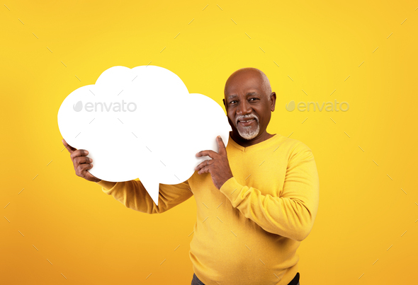 Senior black man holding empty speech bubble on orange studio background, mockup