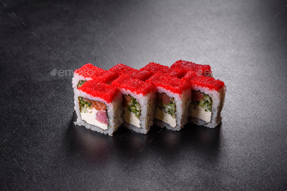 Traditional delicious fresh sushi roll set on a black background