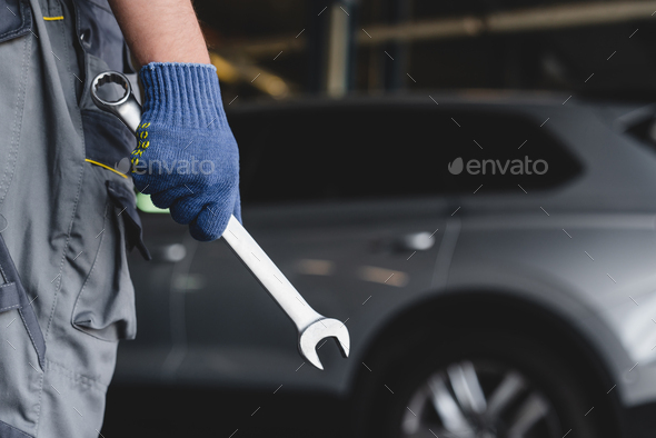 Wrench in technician mechanic hands. MOT. Vehicle inspection. Repairing fixing car tires wheels