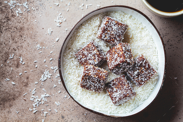 Vegan coconut and dates energy squares in coconut bowl.