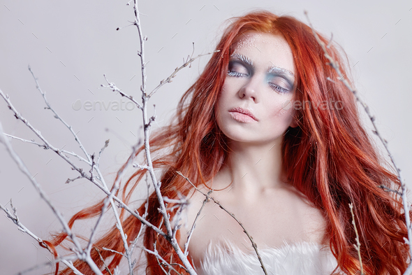 Redhead girl with long hair, a face covered with snow with frost. White eyebrows and eyelashes in