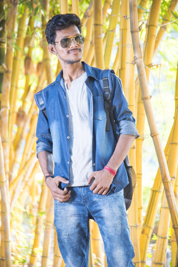 Handsome happy young man on bamboo background. Stock Photo by crshelare