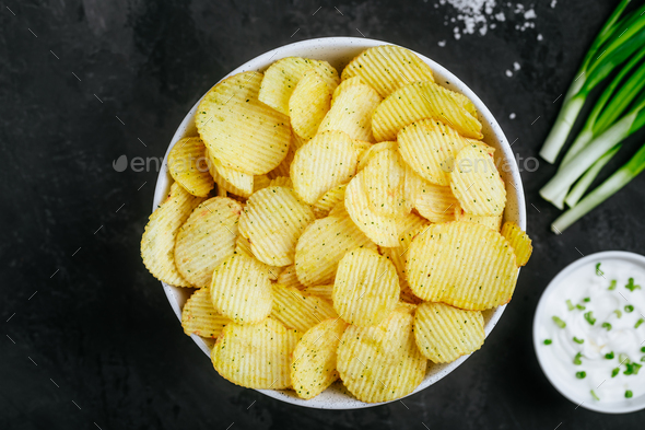 Potato chips. Crispy potato chips and sour cream with onion - Stock Photo - Images