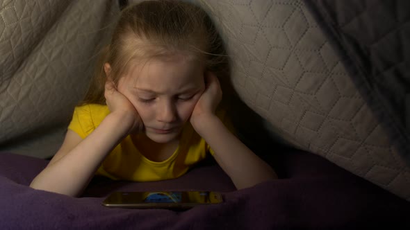 Little Girl With Phone On Bed alt
