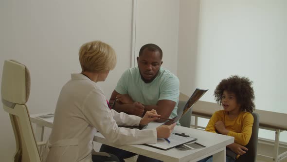 Pediatrician Holding Mri Scan Giving Medical Consultation to Father for Treatment Illness of Child alt