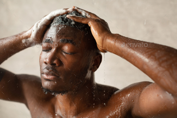African American Male Washing Head Relaxing Under Water In Bathroom - Stock Photo - Images