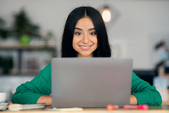 Closeup portrait of indian young woman freelancer working on laptop - Stock Photo - Images