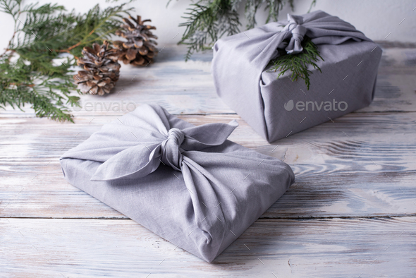 Two christmas gifts wrapped in gray linen cloth, zero waste concept.
