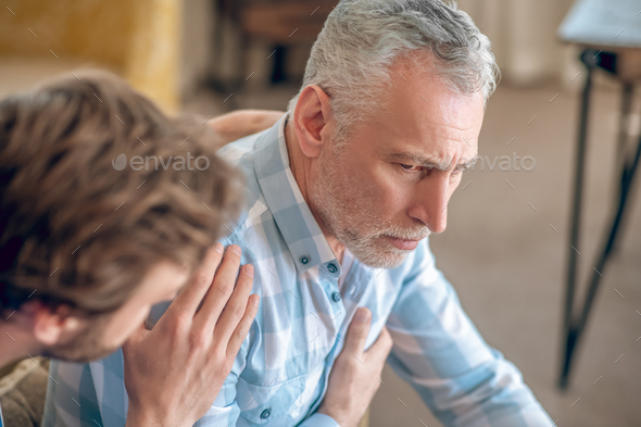 Geriatric physician taking care of a sad ill patient - Stock Photo - Images