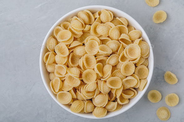 Orecchiette pasta. Dry Uncooked Orecchiette Italian Pasta in bowl on gray stone background. - Stock Photo - Images