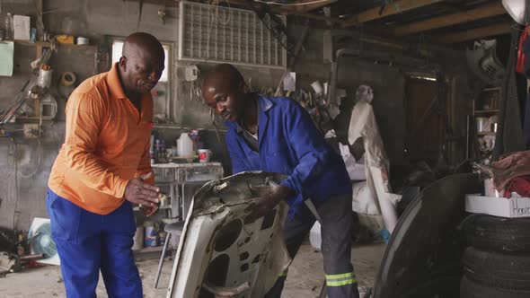 African men sanding a car alt