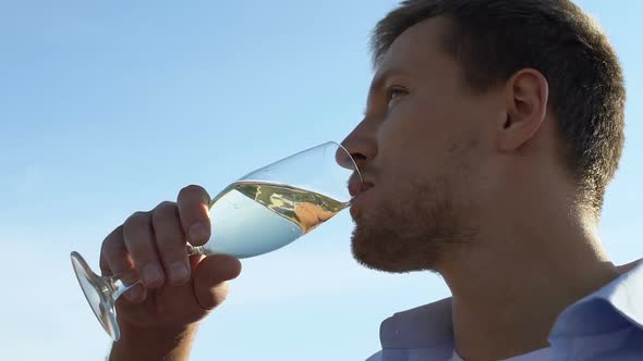 Handsome Young Man Drinking Glass of Wine at Party, Celebrating Success ...