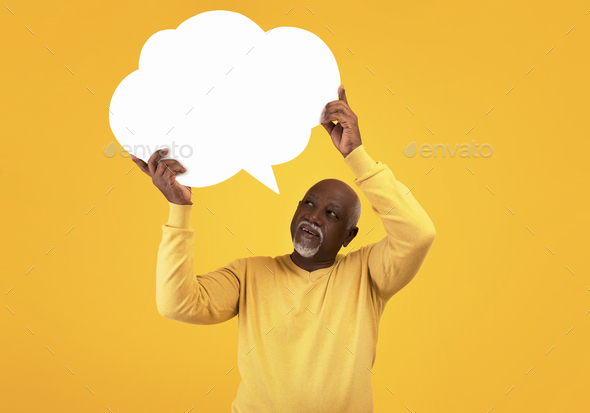 Elderly black man holding blank speech bubble with mockup for your ad on orange studio background