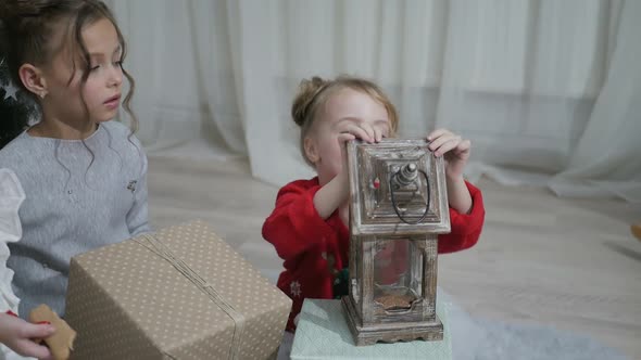 Happy American family celebrating Christmas. Children open a gift at home. alt