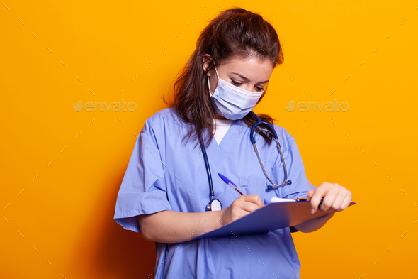 Portrait of woman with face mask and taking notes