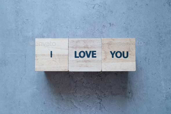 I love you more stamp letters on wood blocks on the old concrete