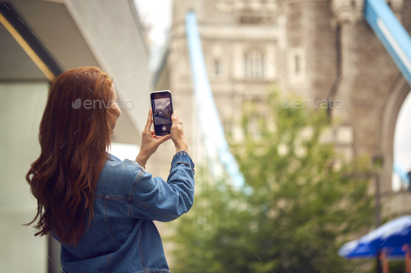Female Vlogger Or Social Influencer In London Taking Photo On Mobile Phone Of Tower Bridge - Stock Photo - Images