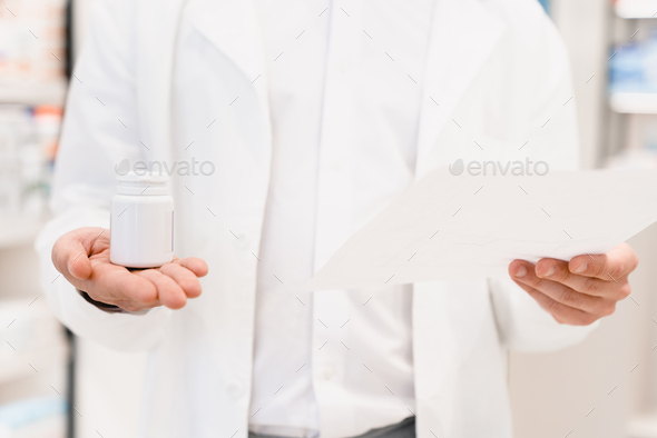 Pharmacist looking prescription for expiration date, side effects, active substance of drugs, pills