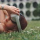 A girl wearing on the vr glasses while relaxing on the grass - VideoHive Item for Sale