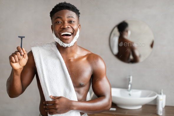 Excited Black Man Holding Safety Razor In Bathroom