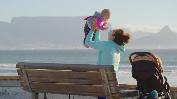 Caucasian Woman with Baby on Bacground Table Mountaine Wearing a Protective Face Mask To Prevent alt