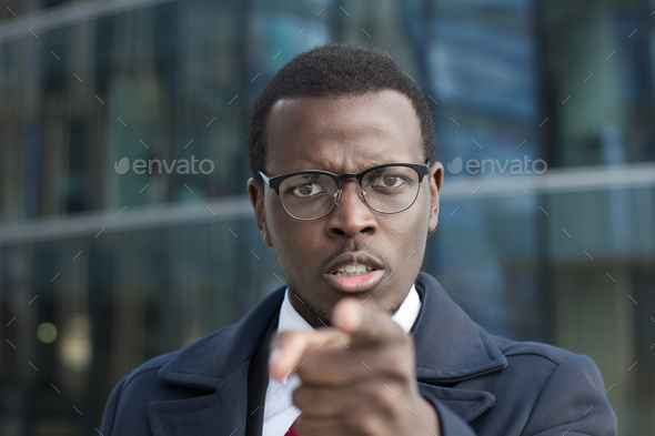 Young African american executive points with index finger as if found solution