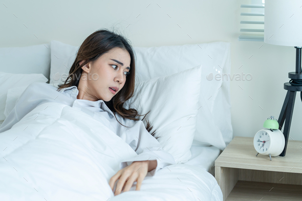 Asian attractive young woman feel shock after wake up late in bedroom.