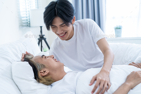 Asian handsome gay talk with boyfriend after wake up from sleep on bed.