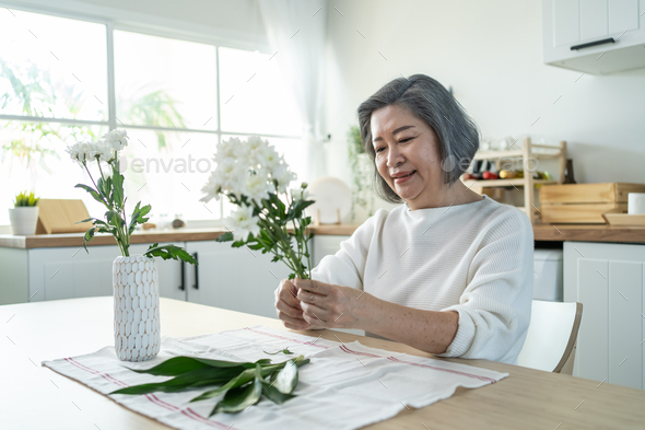 Vases with Beautiful Flowers on Table in Kitchen Interior. Stock