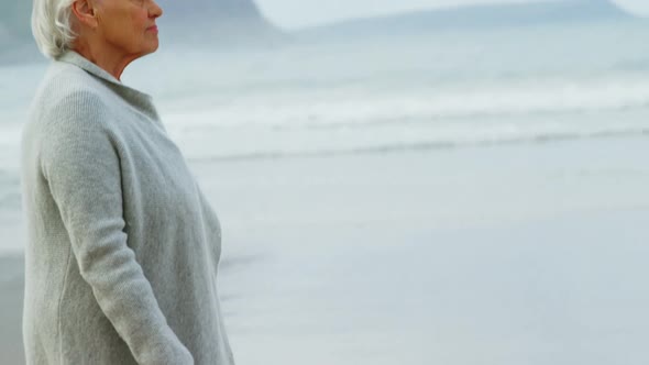Senior woman walking on beach alt
