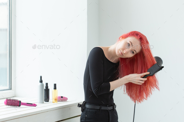 Hairdresser, style, people concept - woman id blowing dry her colored hair