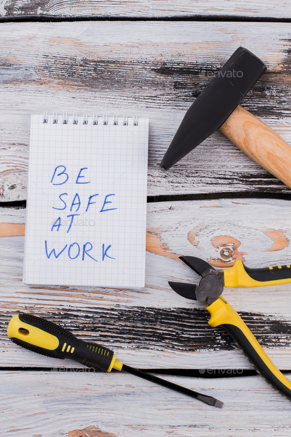 Be safe at work slogan and tools for repairing or construtcing.