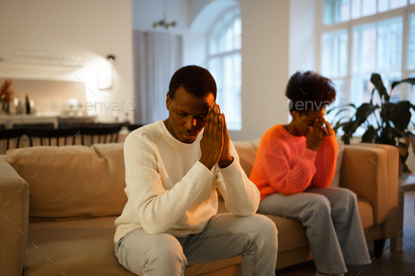 Young Upset African Married Couple Sit On Sofa At Home And Feeling