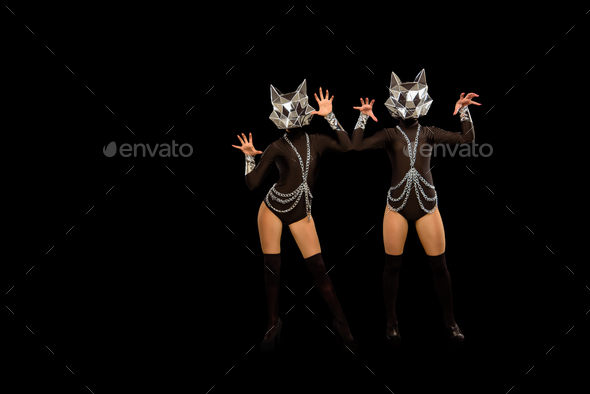 Two go-go variety show dancers in wolf masks on black