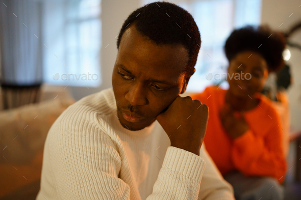 Heartbroken black man avoid looking at cheating wife asking for forgiveness. Relationship crisis
